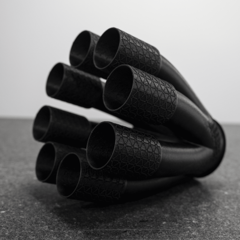 Large black FDM-printed exhaust header with eight runners built as a single piece