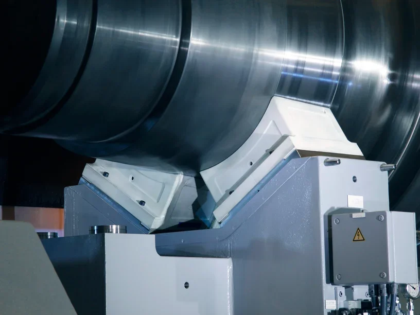 SLS-printed nylon protective covers on steady rests supporting a large steel roll