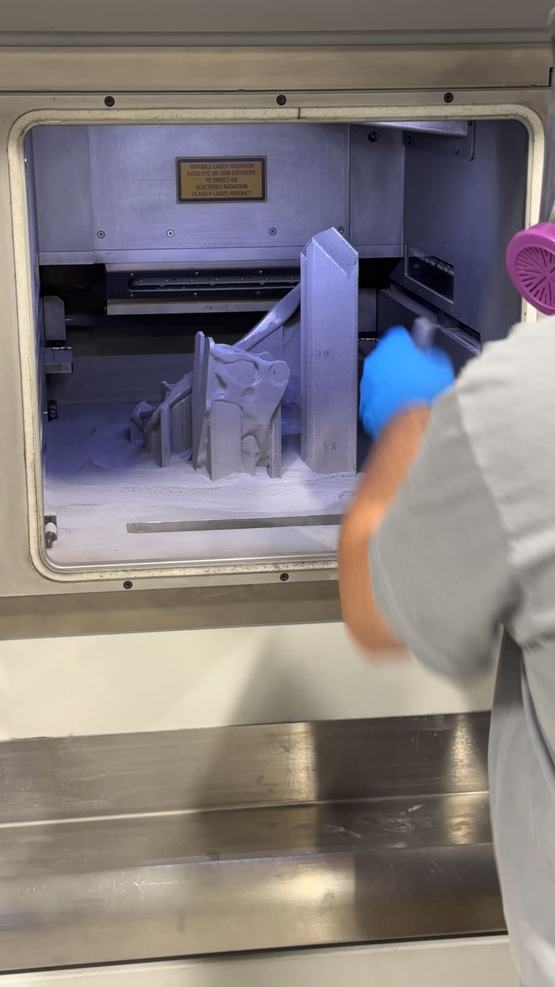 An operator removing the printed parts from the machine