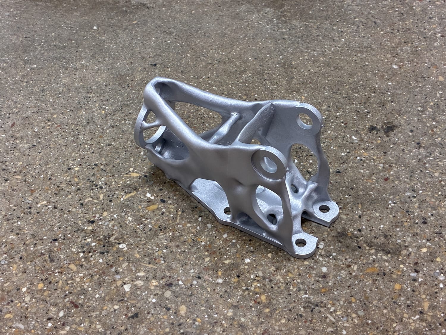 A finished DMLS aluminum handbrake mount printed in North America by Evology