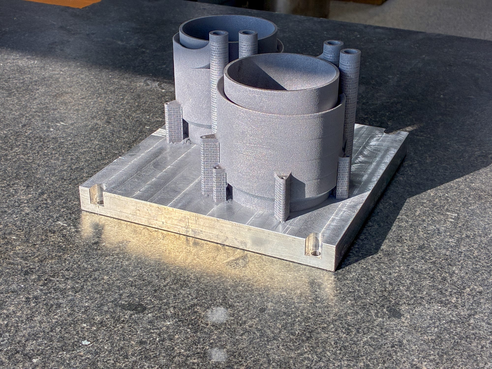 The cooling sleeves as printed, still in supports on the DMLS build plate