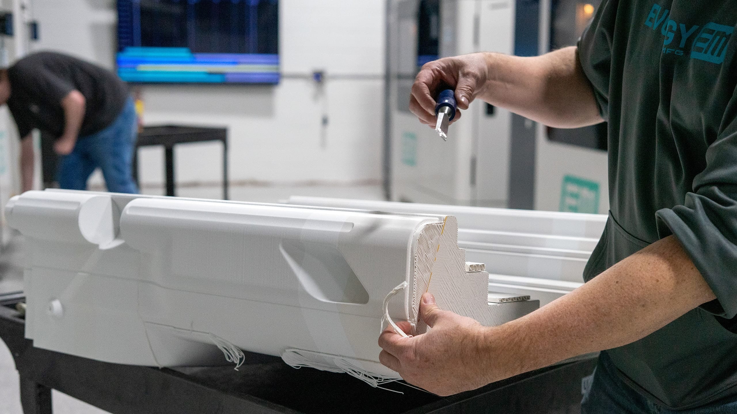 An Evology technician finishing a large white printed MRI table section
