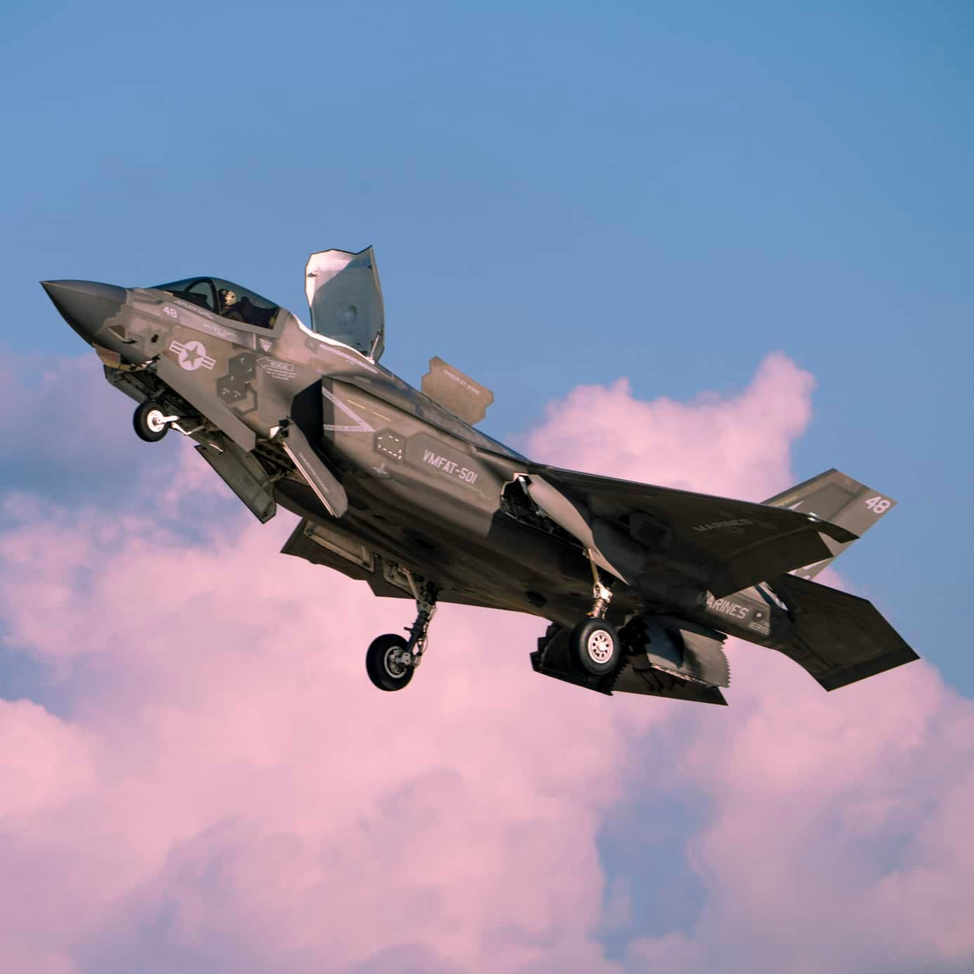 Fighter jet in flight against a cloud-streaked sky