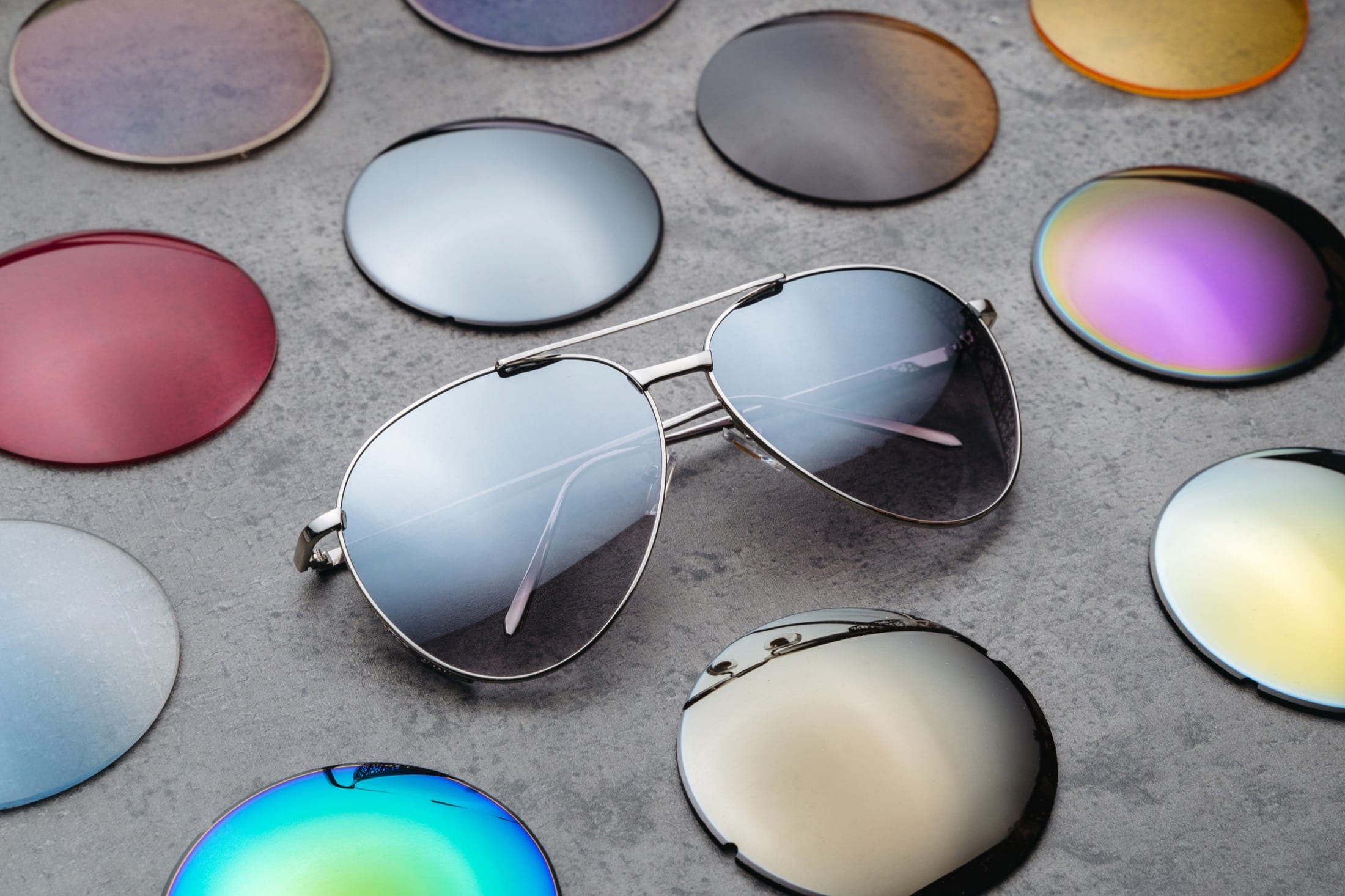 Sunglasses and an assortment of colored lenses on a tabletop